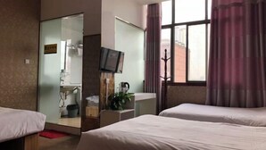 A hotel room with two beds, a television, a window with curtains, and a view of a building outside. - Guzhen Zihao Hotel (Guzhen)