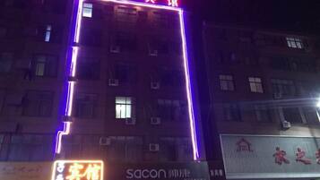 A building with illuminated signage, multiple windows, and a visible entrance.