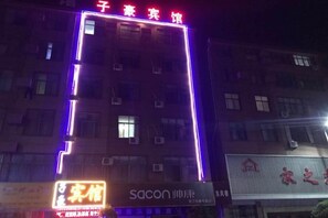 A building with illuminated signage, multiple windows, and a visible entrance. - Guzhen Zihao Hotel (Guzhen)