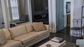 A living room with a sofa, coffee table, and patterned chairs. - Downtown Victorian Flat Great Location and free Parking (Chattanooga)