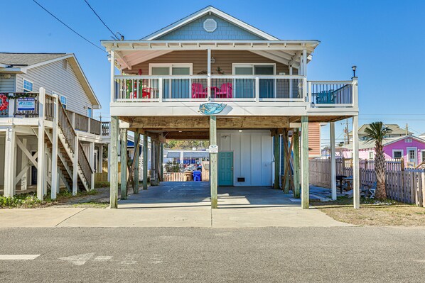 A two-story house with a balcony, a wooden deck, and a sign indicating a rental property. - Ocean-View 'Sea Gem' Bungalow: Steps to Beach! (Carolina Beach)