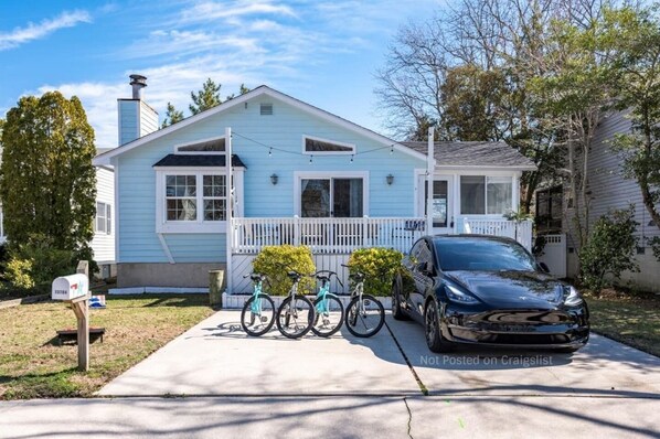 Ein eingeschossiges Haus mit Veranda, Briefkasten und geparktem Auto.