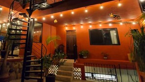 A multi-story building with a spiral staircase, outdoor lighting, and potted plants. - Ivan's Bella Vista: Top-Floor 2BR, Bay Views, Heated Pool, Walkable (Puerto Vallarta)