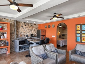 Curiel's Retreat: kitchen by the stone wall, arch through to a bedroom