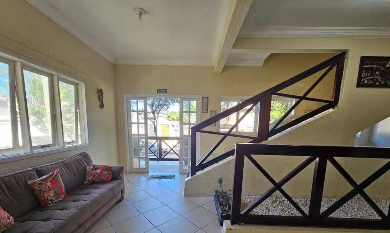 A hotel lobby with a staircase, a sofa with cushions, and a door leading outside.