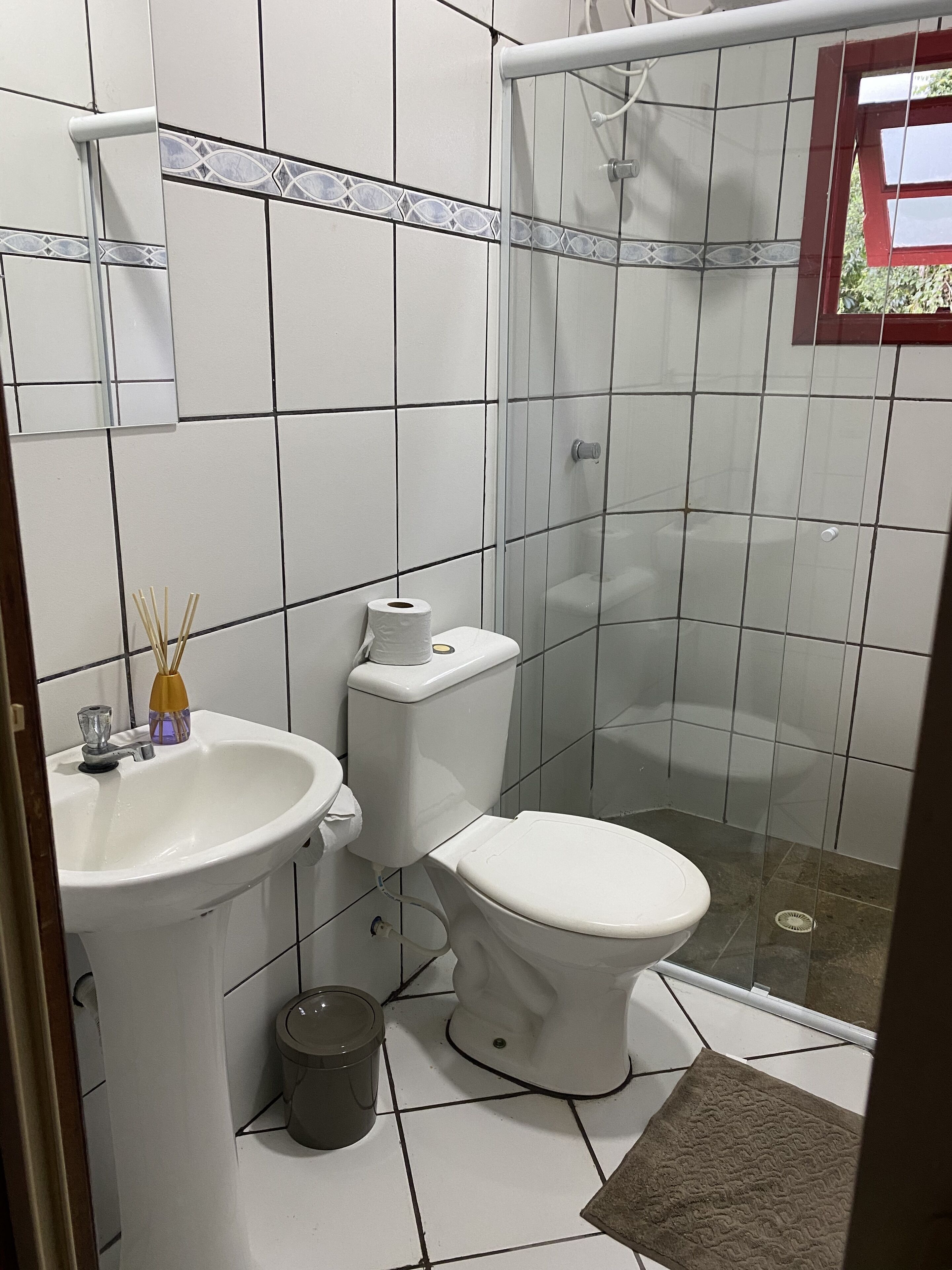 A bathroom with a white sink, toilet, and shower.