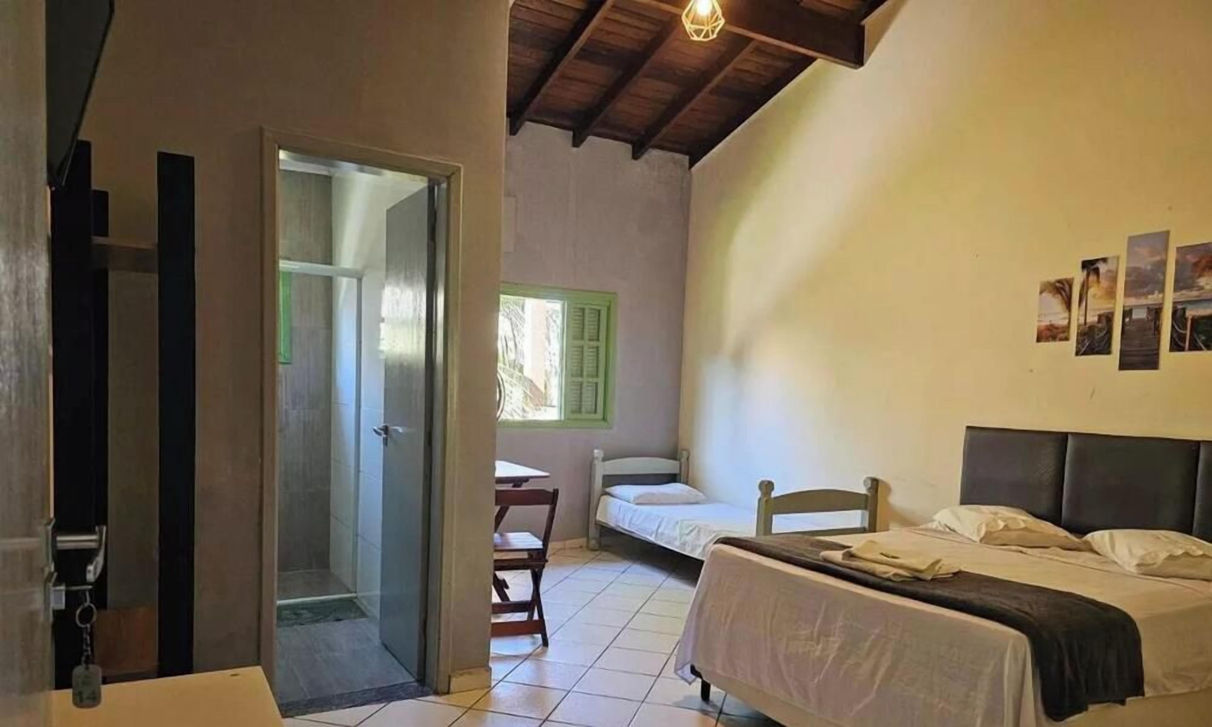 A room with a bed, a desk, and a shower area.