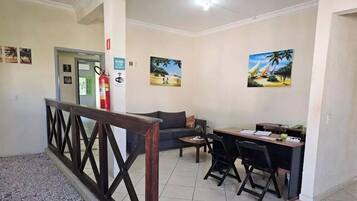Un vestíbulo de hotel con una recepción, un sofá, una mesita de café y un extintor.