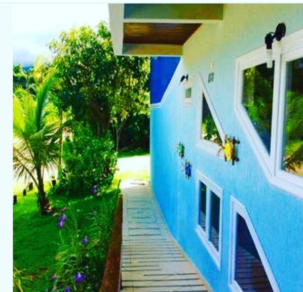Un camino que lleva a un edificio con múltiples ventanas y fachada azul.