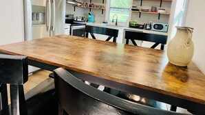 A modern kitchen with a wooden table, black chairs, a refrigerator, and a window with a view of greenery. - Lakefront Home w/ Dock on Old Hickory Lake (Gallatin)