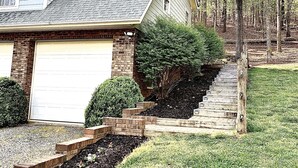 A two-story house with a garage, a brick chimney, and a well-maintained lawn. - The Relaxing Oaks (Columbus)