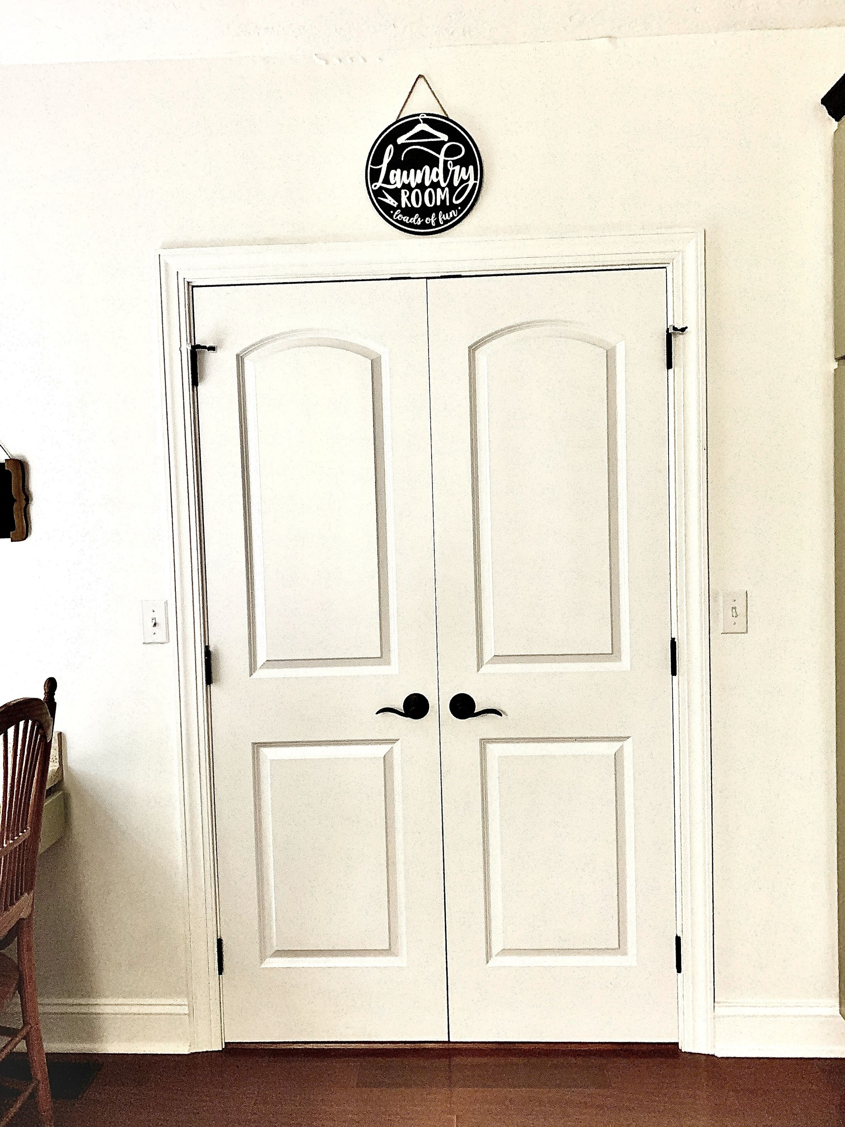A white double door with a sign above reading 'Laundry Room' and 'loads of fun.'