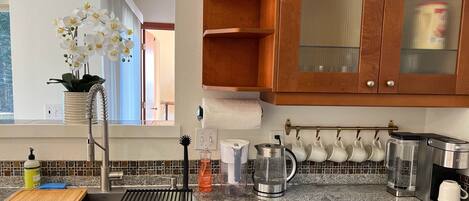 Una cocina moderna con encimera de granito, electrodomésticos de acero inoxidable y armarios de madera.