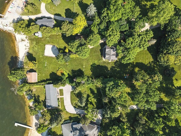Ett flygbildsbild av ett bostadsområde med hus, en brygga och en sjö.