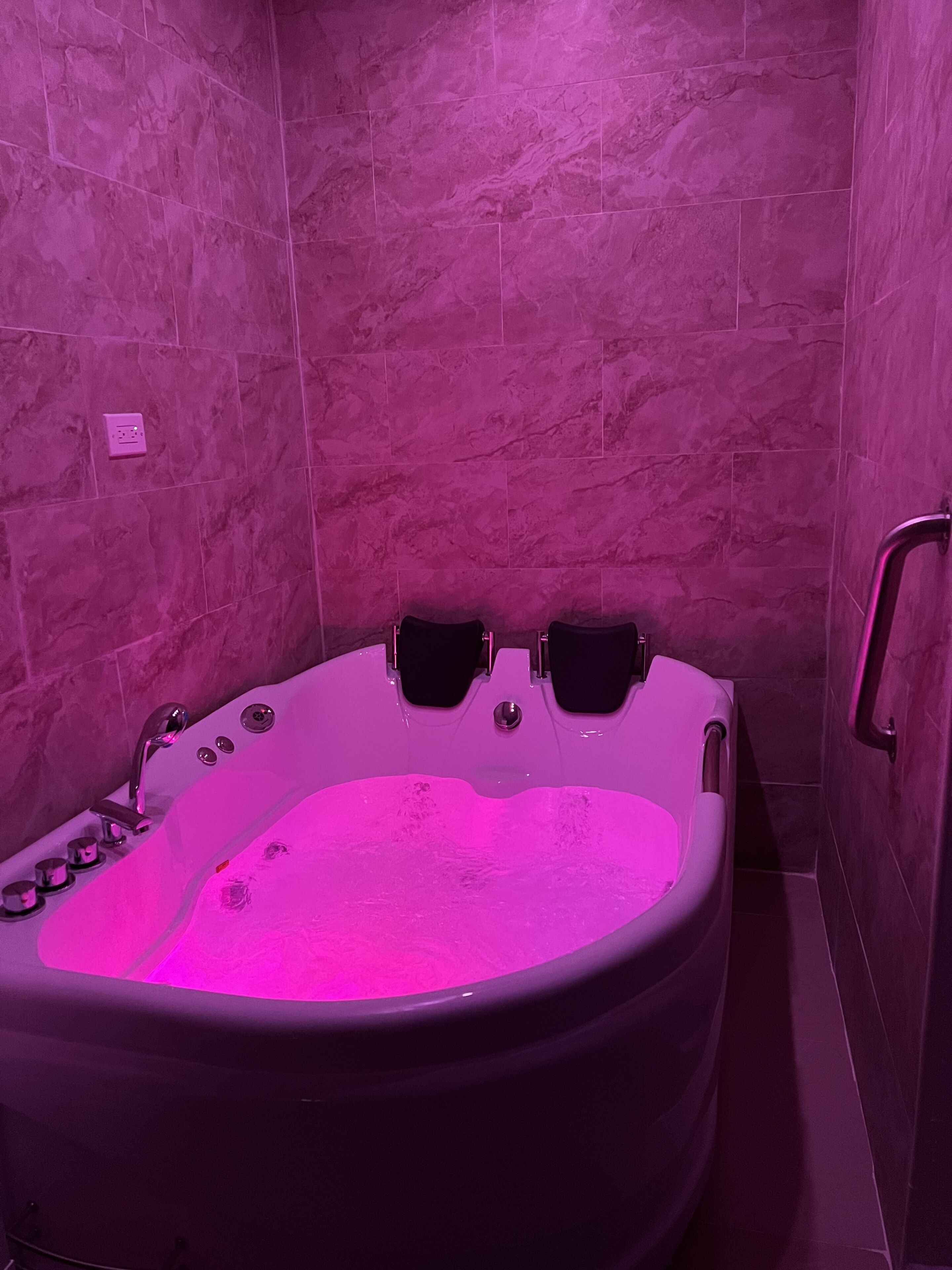 Un bagno con una vasca freestanding, una zona doccia e un corrimano.