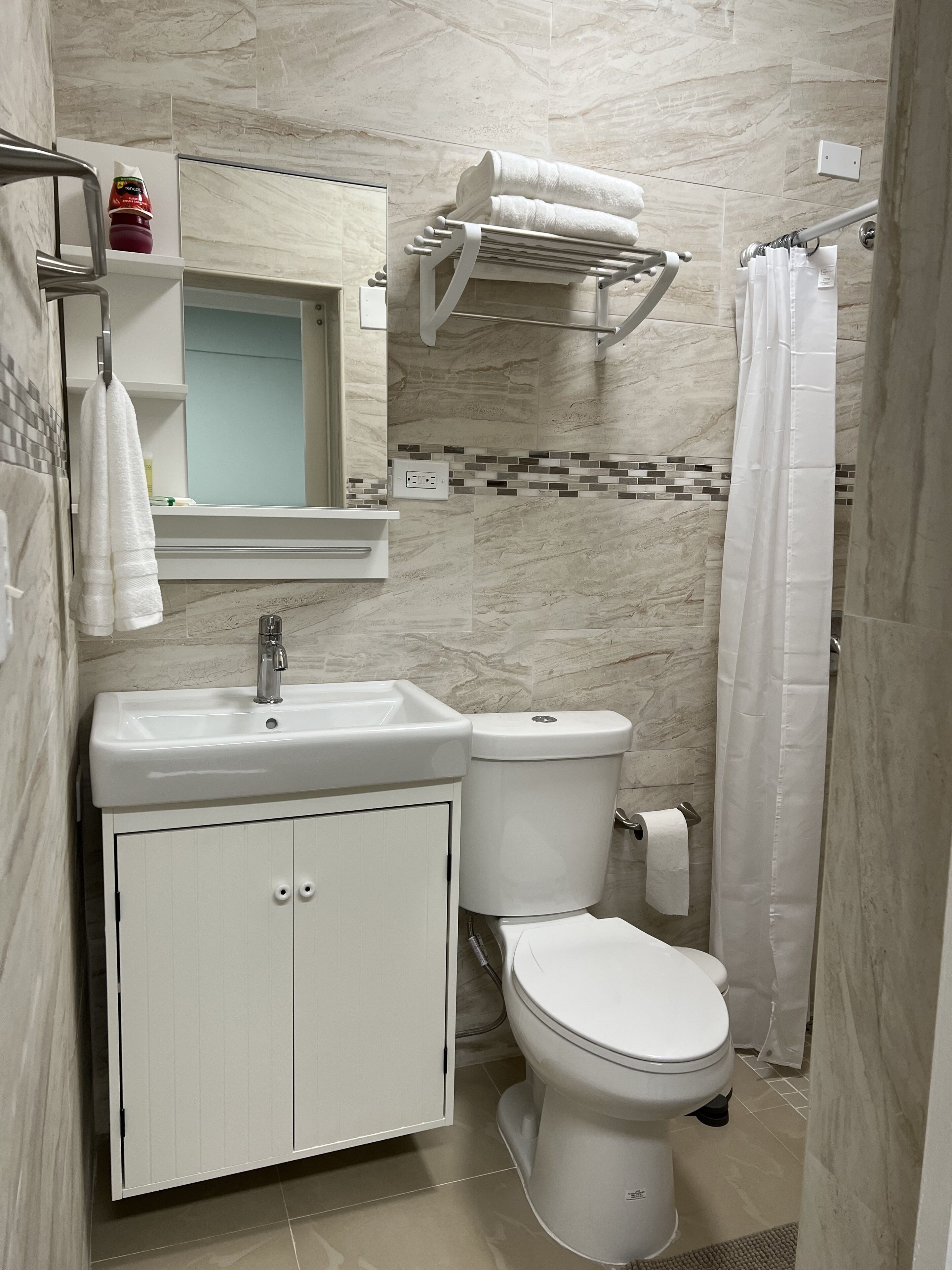 Een badkamer met een wastafel, toilet en een handdoekhouder.