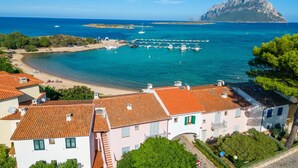 Une ville côtière avec des bâtiments, une plage et une montagne en arrière-plan.