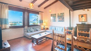 Une pièce confortable avec un canapé, une table et une vue sur la mer.