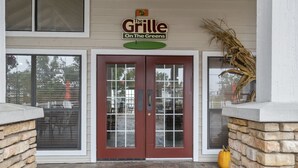 Rakennuksen sisäänkäynti, jonka yläpuolella on kyltti, jossa lukee: ”The Grille On The Greens”.