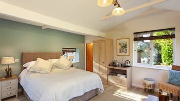 A bedroom with a large bed, bedside tables, a wardrobe, a window with a view, and a ceiling fan.