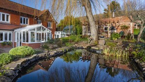 A residential property with a conservatory, a pond, and a garden. - The Garden Studio, Woodcombe (Minehead)