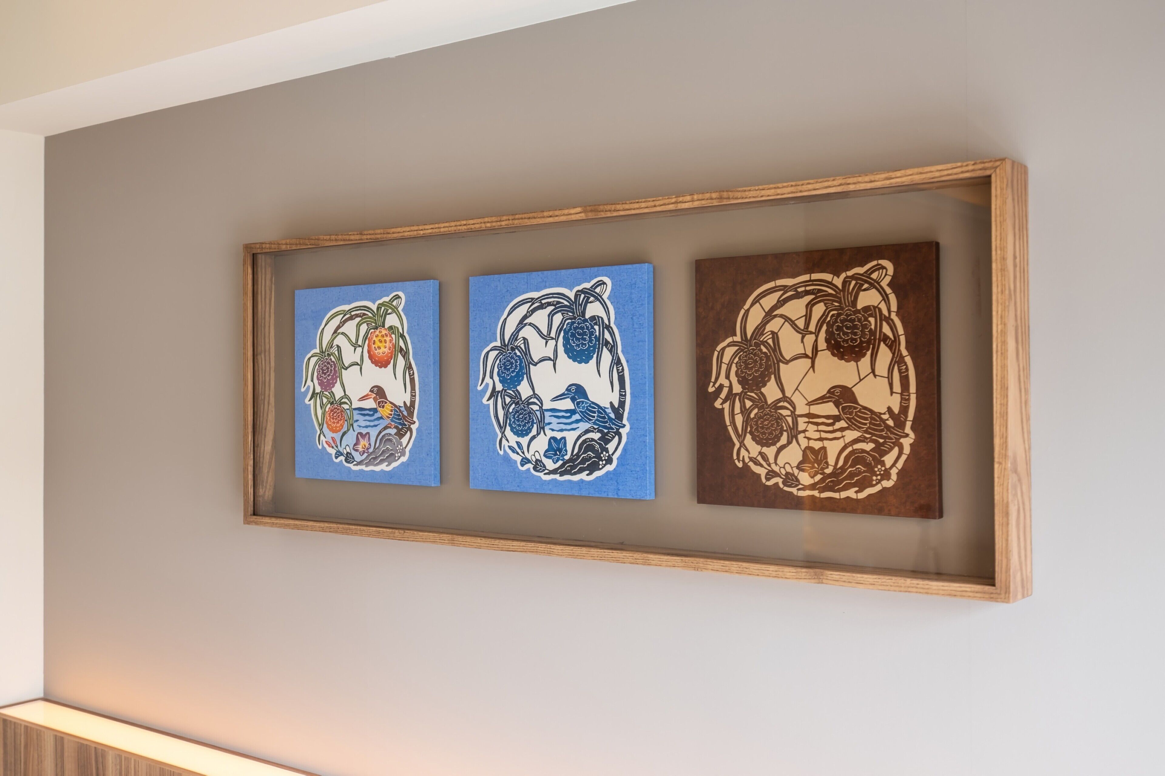 Three framed artworks on a wall.