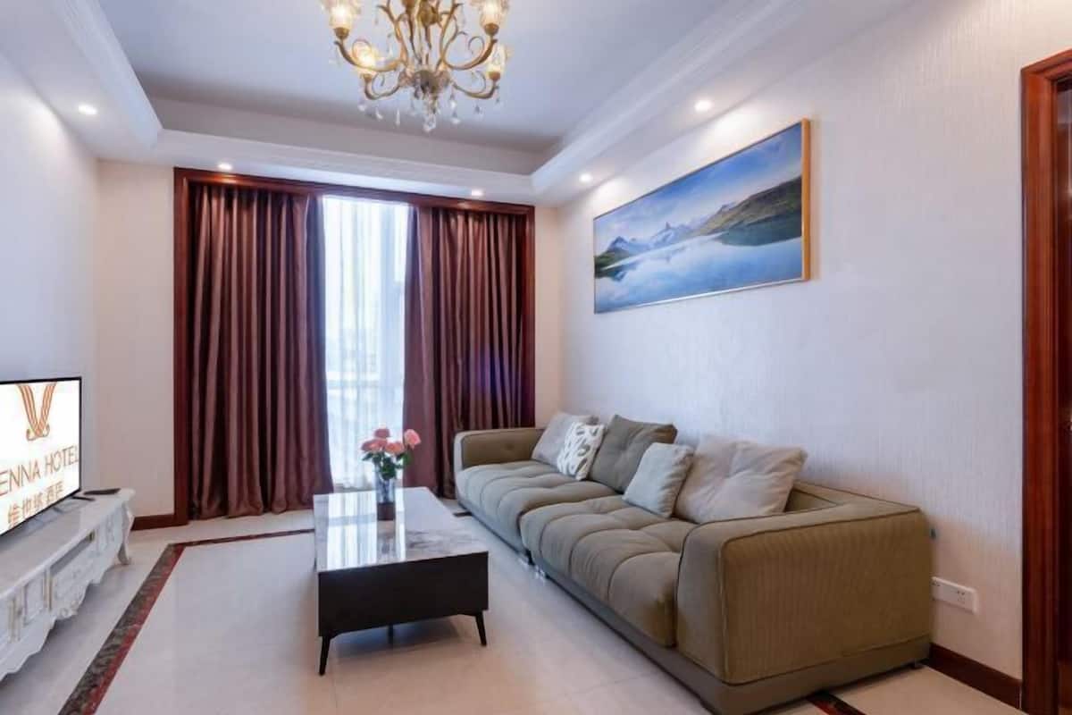 Ein modernes Wohnzimmer mit einer Couch, einem Couchtisch und einem Fernseher.