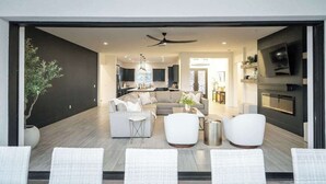 A modern living room with a sofa, chairs, a coffee table, and a fireplace.
