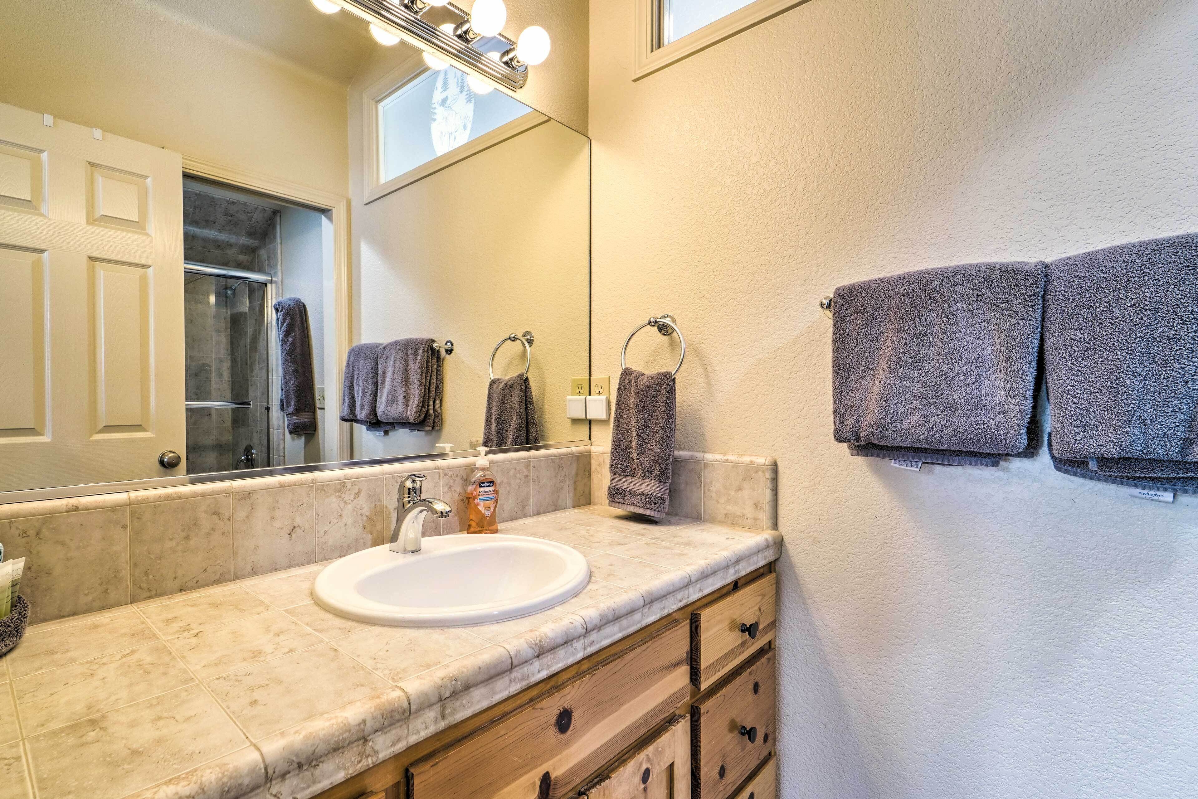 A bathroom with a sink, mirror, and towel rack.