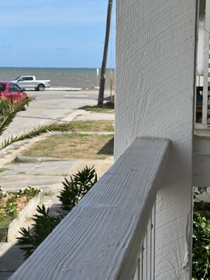 Stunning hotel exterior with a textured facade, set amidst lush greenery and a scenic ocean view.