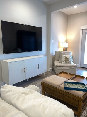 Relax in this stylish living room with a large flat-screen TV, comfortable sofa, and wooden coffee table.