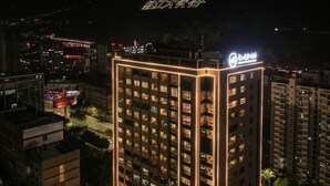 Un edificio alto con ventanas iluminadas y un letrero en la parte superior.