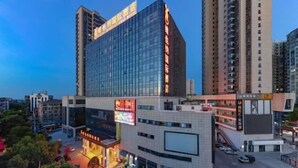 Un hôtel moderne doté d’une façade en verre, de plusieurs étages et d’une enseigne bien visible.