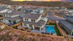 A residential area with modern houses, a swimming pool, and a hilly landscape in the background. - Paseos Poolhouse by RedAwning (Washington)