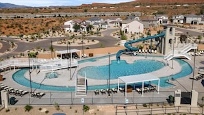 A resort with a swimming pool, a water slide, and a desert landscape in the background. - Paseos Poolhouse by RedAwning (Washington)