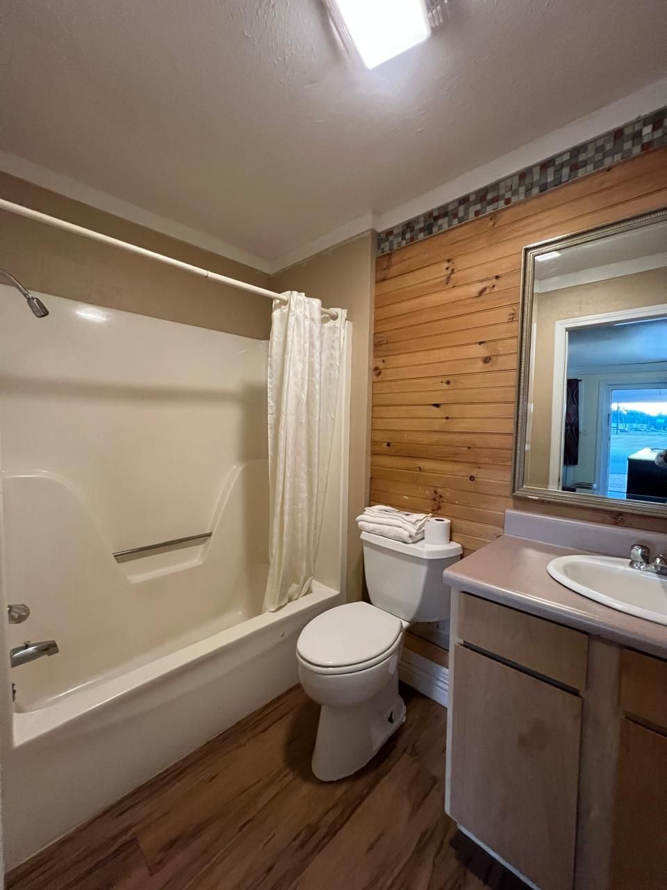 A bathroom with a bathtub, toilet, and sink.