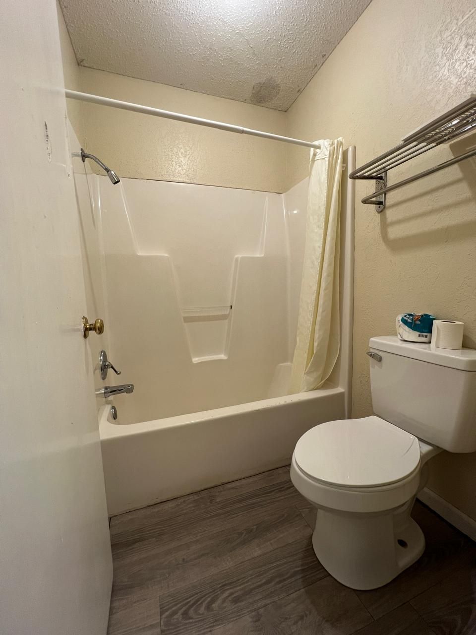 Un baño con bañera, inodoro y cortina de ducha.