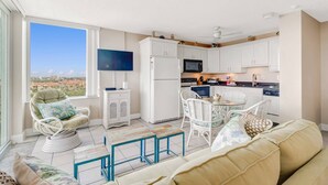 Una sala de estar moderna con un sofá, sillas, una mesa de centro y un televisor.