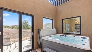 Ein Wellnessbereich mit Whirlpool, Schiebetüren und Blick ins Freie.