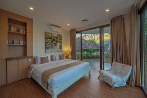 Une chambre avec un grand lit, une chaise, une bibliothèque et une vue sur l’extérieur.