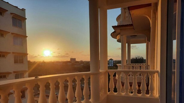 A balcony with a balustrade overlooking a sunset. - Stay.Plus Queen's Royal Apartments Nyali (Mombasa)