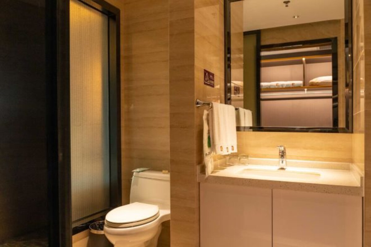 A modern bathroom with a toilet, sink, and mirror.