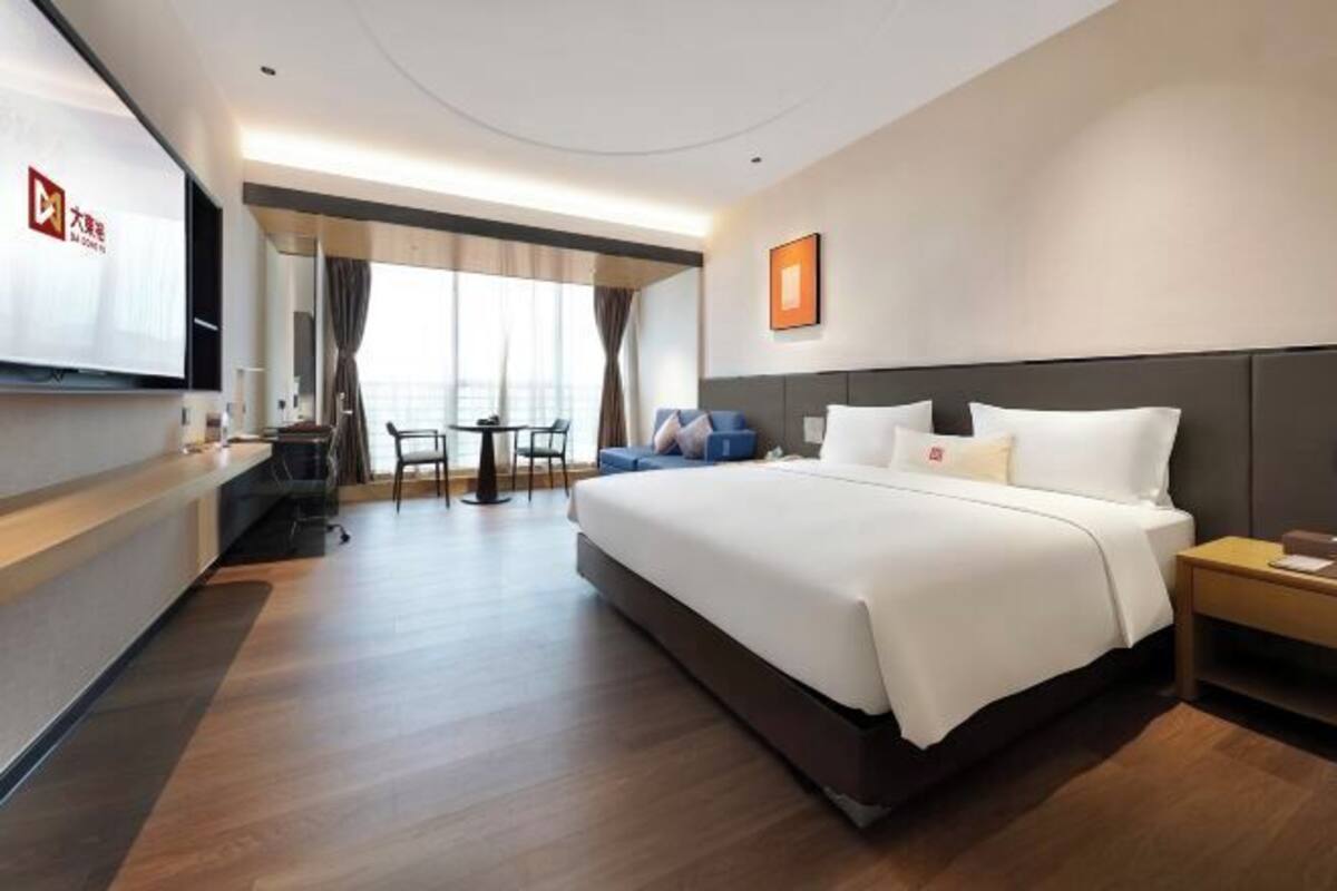 Una camera d'albergo con un letto grande, una scrivania, una sedia e una televisione.