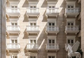 Facciata di un edificio con numerosi balconi, ognuno dotato di balaustra bianca.