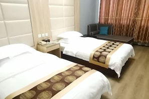 Een hotelkamer met twee bedden, een bureau, een stoel en een telefoon.