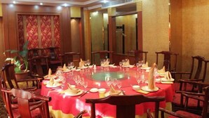 A conference room with a round table set for a meeting, surrounded by wooden chairs. - Fuhua Hotel (Shouguang)