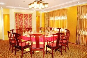 A conference room with a round table, chairs, and a chandelier. - Fuhua Hotel (Shouguang)