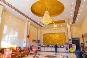 A hotel lobby with a reception desk, seating area, and a chandelier. - Fuhua Hotel (Shouguang)