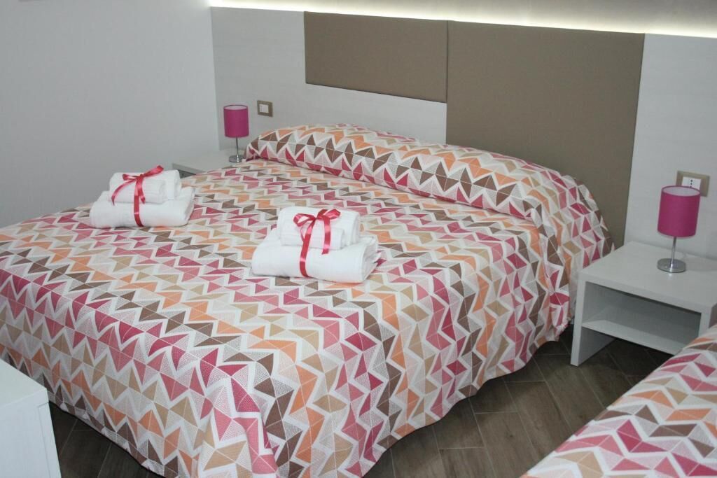 Ein Hotelzimmer mit einem Bett, zwei Nachttischen und einem Kopfteil.