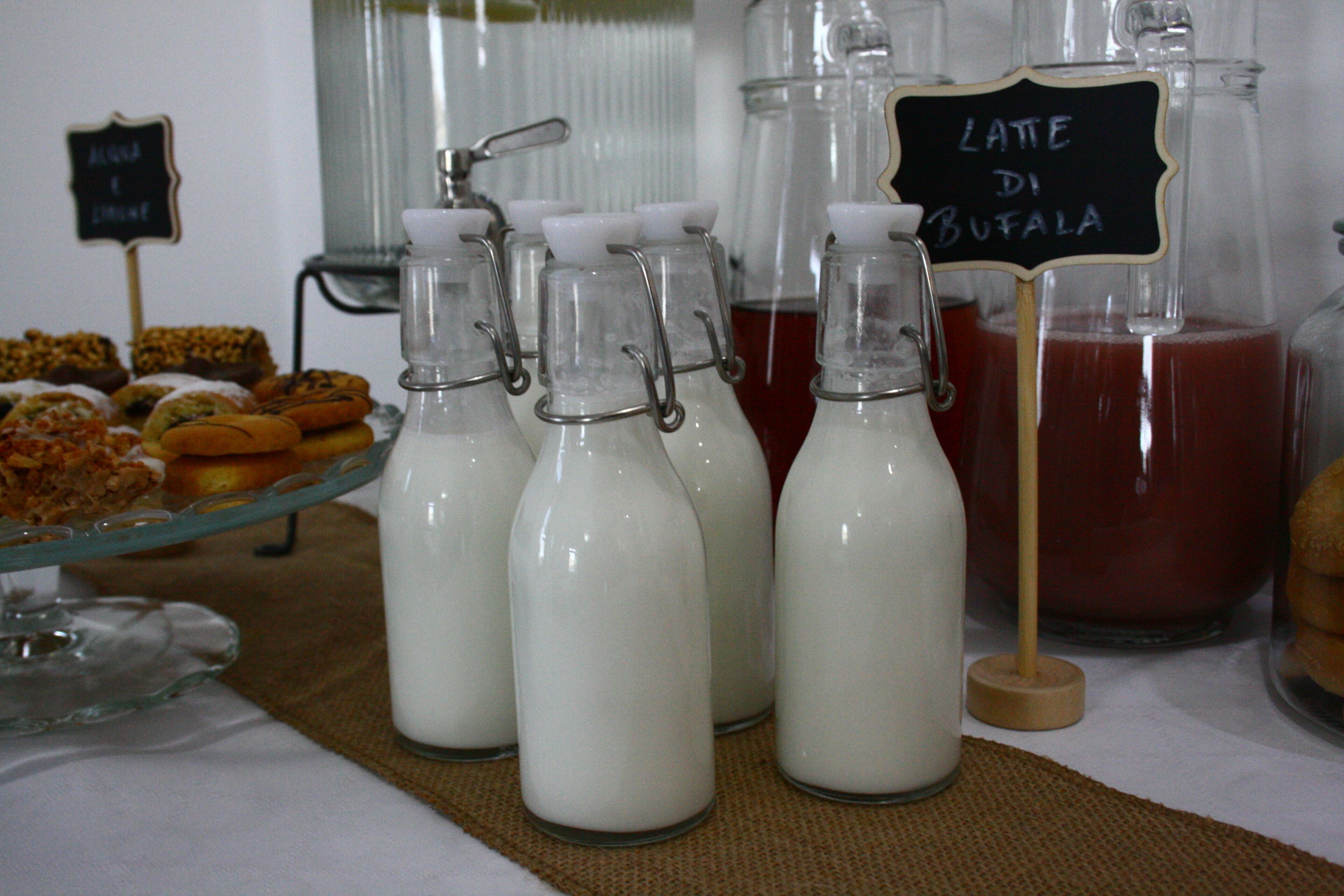 Exhibición de botellas de leche y un letrero que indica 'Latte di Bufala'.